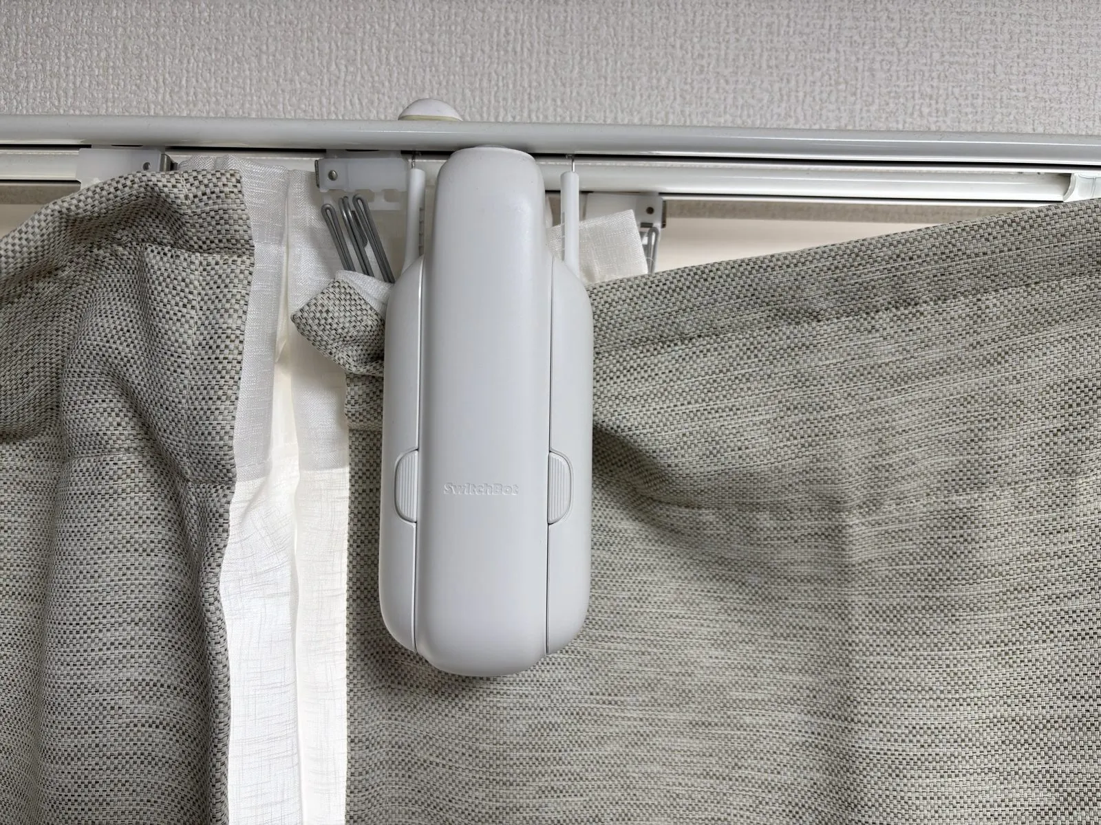 カーテンレールに取り付けたSwitchBotカーテン本体。ランナーの間にぶら下がる形で固定される