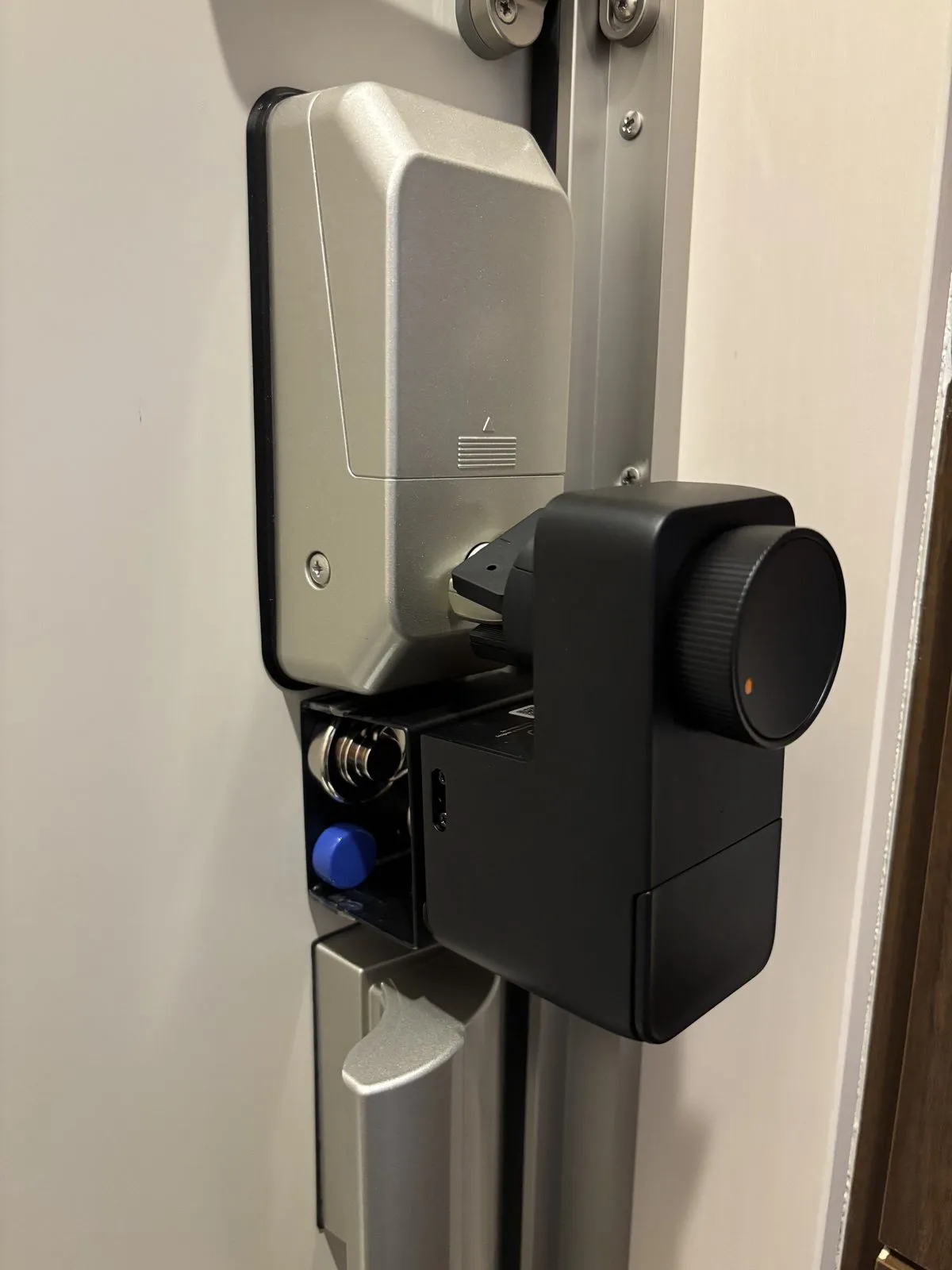 カードキー式電気錠の大きなつまみに合わせ、自作スペーサーで嵩上げして取り付けたロックPro。スペーサーはネオジム磁石でドアに固定している