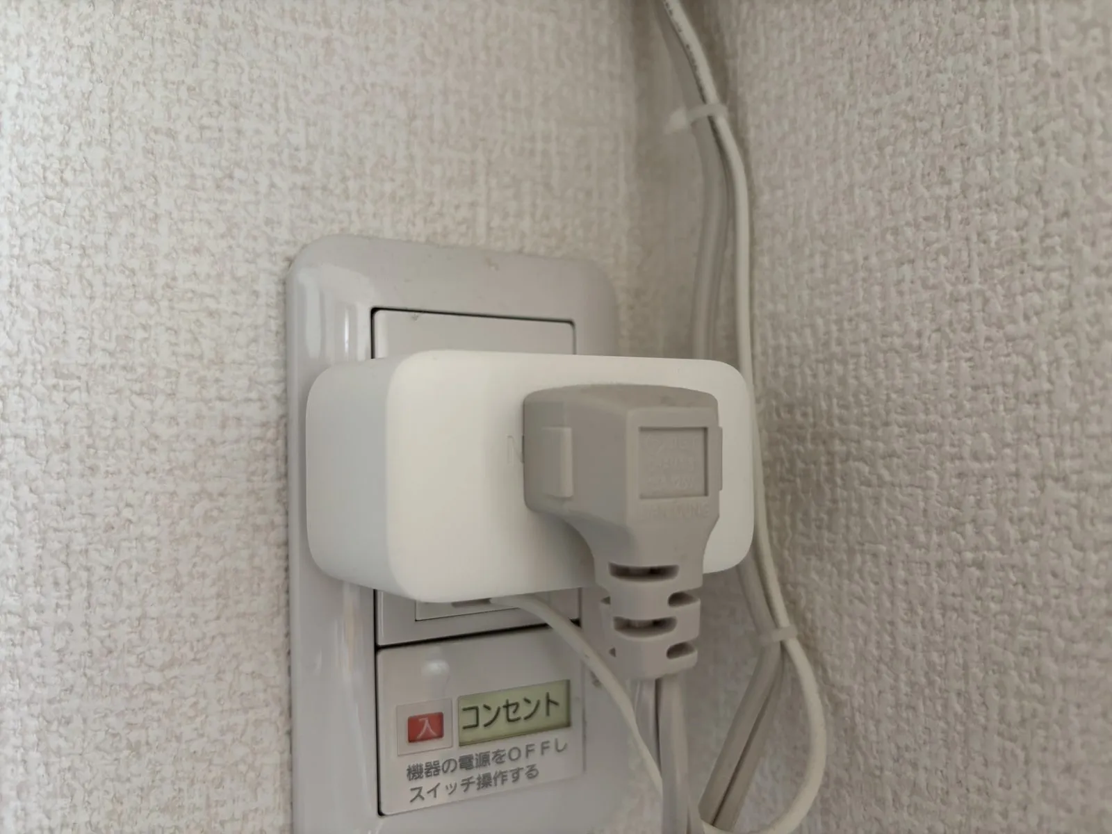 エアコン専用コンセントに設置したプラグミニ。壁のコンセントにプラグミニを挿し、その上にエアコンの電源プラグを挿している